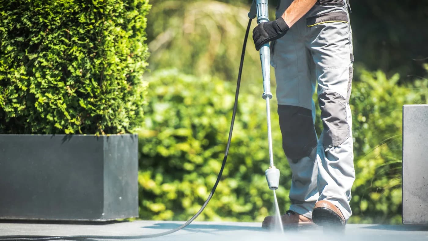 Patio paving being jet washed next to a planter